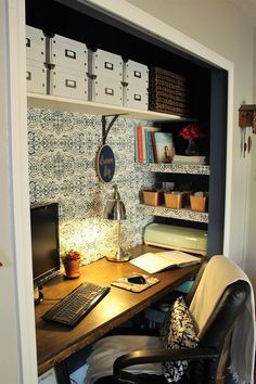 a desk with a laptop computer sitting on top of it next to a book shelf