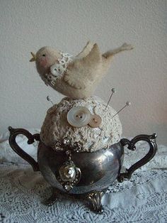 a teapot with two birds sitting on top of it