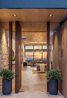 the entrance to a modern home with two large planters