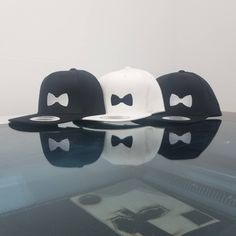 three hats sitting on top of a reflective surface