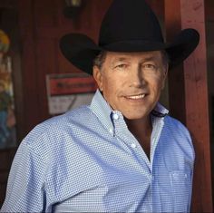 a man wearing a cowboy hat standing in front of a building