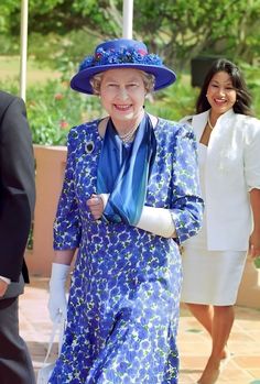 an older woman wearing a blue dress and hat