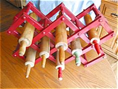 a red rack with several rolls of dough in it on top of a wooden floor