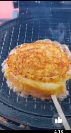 an omelet is being grilled on the grill with a wooden skewer