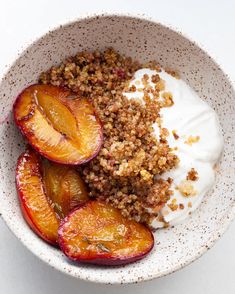 a bowl filled with fruit and yogurt on top of a white tablecloth