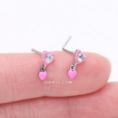 Get ready to add some colorful fun to your nose piercing with the Pink Power Iridescent Puffy Heart Dangle Nose Stud Ring! This unique piece features a playful pink heart with an iridescent center gem, adding a touch of whimsy to your look. View All Colors/Styles Material: Acrylic, 316L Stainless Steel Size: 20 GA (0.8mm), 9/32" (7mm) Charm measures 10 x 5mm Suitable for Nostril Piercings It is always recommended to know your exact piercing size to ensure fitment, safety, and comfort. Please con Pink Heart-shaped Body Jewelry For Valentine's Day, Hot Pink Nose Ring, Pink Heart-shaped Kawaii Jewelry, Pink Heart-shaped Adjustable Earrings, L Shaped Nose Ring, Pink Heart-shaped Glass Jewelry, Pink Power, Puffy Heart, Nose Stud