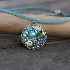 a necklace that is sitting on top of a piece of wood with beads in it