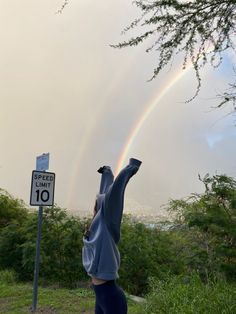 a person reaching up into the air to catch a rainbow in the sky above them