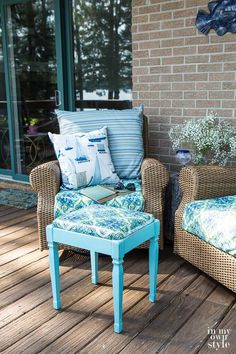 two wicker chairs sitting on top of a wooden deck