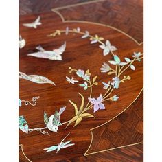 a wooden table with birds and flowers painted on it