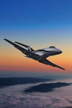 an airplane flying in the sky above some clouds