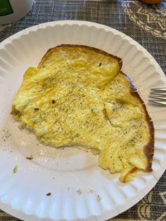 an omelet on a paper plate with a fork