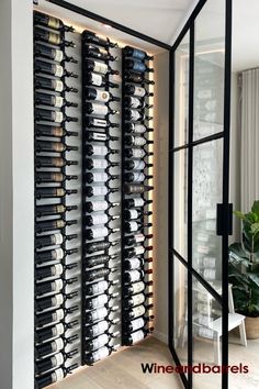 a wine rack in the corner of a room filled with bottles and glasses on display