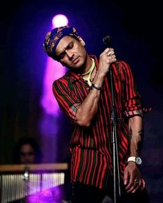 a man standing on top of a stage holding a microphone in front of his face