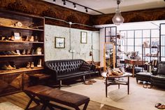 a living room filled with lots of furniture and shelves full of shoes on top of them