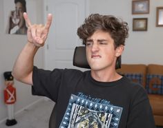 a young man making the peace sign in his living room