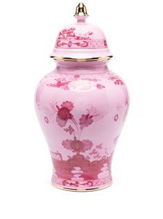 a pink vase with flowers on it and a gold lid in the shape of a urn