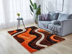 a living room area with a couch, chair and rug in orange and brown tones