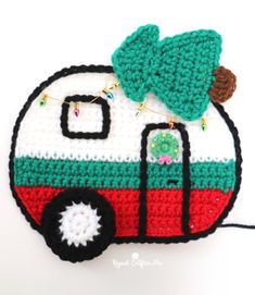 a crocheted camper ornament with a tree on top