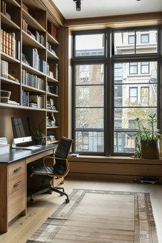 a home office with bookshelves and a large window