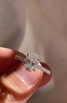 a person holding a diamond ring in their hand