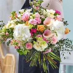 a woman holding a bouquet of flowers in her hands