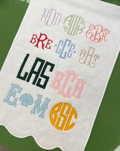 a white towel with different colored letters on it sitting on top of a green table