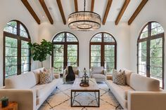 a large living room with arched windows and white couches