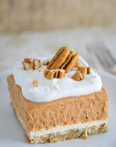 a piece of cake with white frosting and nuts on top