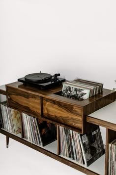 the record player is sitting on top of an entertainment center that has records in it