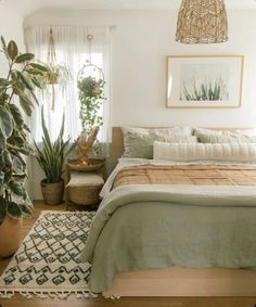 a bedroom with a bed, rug and plants in it