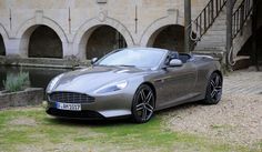 a silver sports car parked in front of a stone building with steps leading up to it