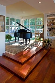 a living room filled with furniture and a grand piano in the middle of the room