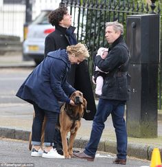 three people and a dog on the street