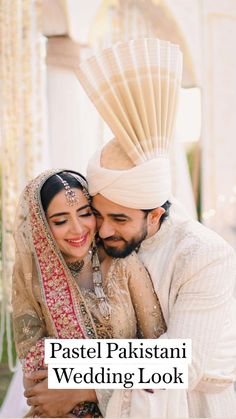 a bride and groom hugging each other in front of an arch