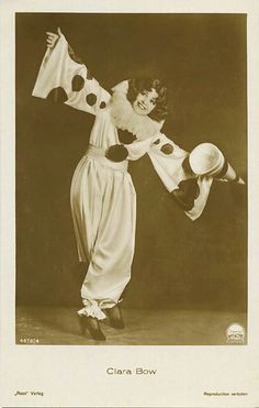 an old photo of a woman dressed in costume and holding a hat on her head