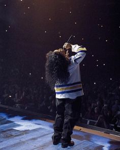 a man standing on top of a stage holding a microphone