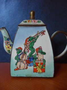 a ceramic teapot with an image of cartoon characters on it