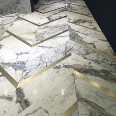 the marble floor is lined with gold trimmings and herringbone pattern on it