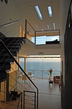 an open floor plan with stairs leading up to the upper level and ocean view in the background