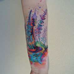 a person's arm with a colorful tattoo on the left side of their arm