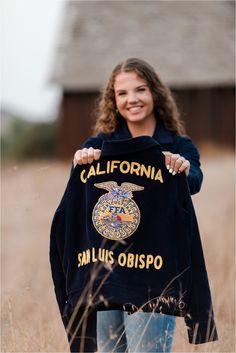 a woman holding up a black shirt with the words california and an eagle on it