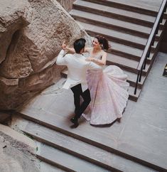 a man and woman are dancing on some steps