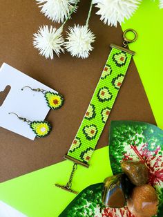 a pair of earrings sitting on top of a table next to some flowers and other items