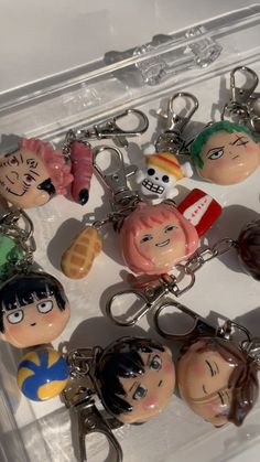 several key chains with cartoon characters on them in a clear plastic case, including one for each person