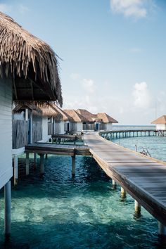 the water is crystal blue and clear with some huts on it's sides that are floating in the ocean