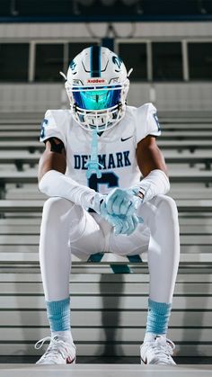 a football player sitting on the bleachers with his hands in his pockets and feet crossed