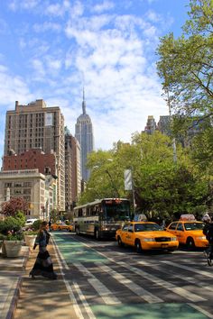 people crossing the street in new york city with yellow cabs and buses on it