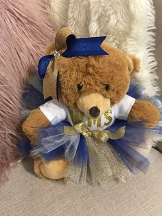 a brown teddy bear wearing a blue and white tutu with the word msu on it's chest