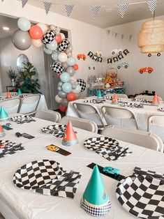 a party with balloons, checkered table cloths and paper hats on the tables